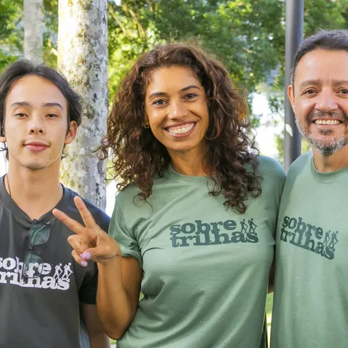 Integrantes da equipe da Sobre Trilhas posam juntos vestindo camisetas da marca.