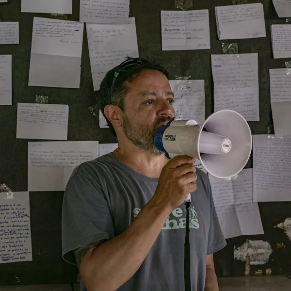 Pessoa declamando ao megafone, em referência ao manifesto da Sobre Trilhas